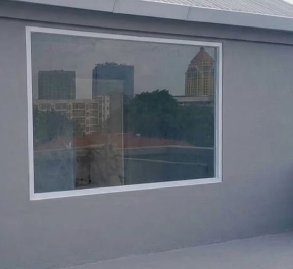 Jendela aluminium modern dengan pemandangan kota di belakangnya.